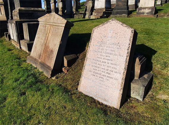 Two gravestones within compartment Omega lying against their base