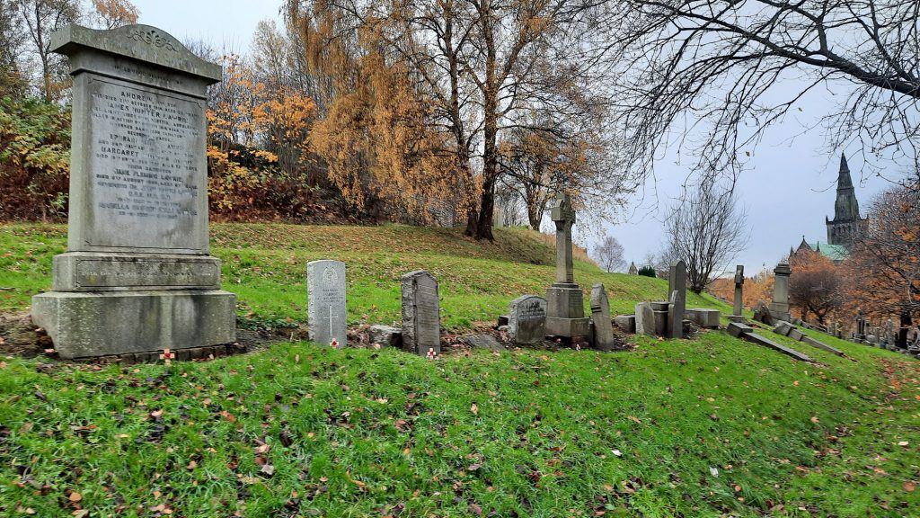 View of moments with Remembrance Crosses. Glasgow Cathedral can be seen in background. Autumn leaves lie on grass