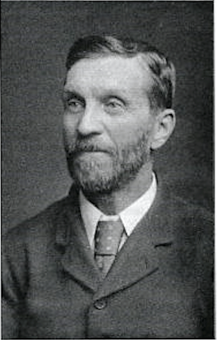 William Doleman - Black and White photograph of a bearded man, from the chest upwards, wearing a dress jacket, white shirt and tie.